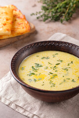 Cheese soup with thyme on a beige background. Vegetarian food.