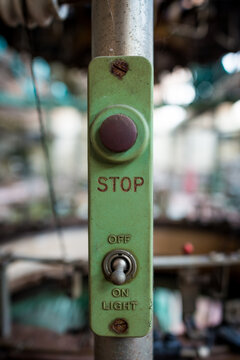 Symmetrical close up of the emergency stop button on an industrial machine in an abandoned Italian textile company