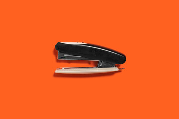 black stapler isolated on the orange background