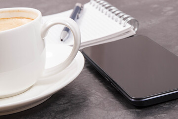 Mobile phone, coffee with milk and notepad for writing notes. Work or relaxation