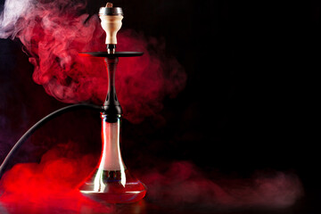 Smoking hookah on black background with color fog