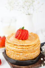 Homemade traditional thin pancakes with berries on a white background, Maslenitsa