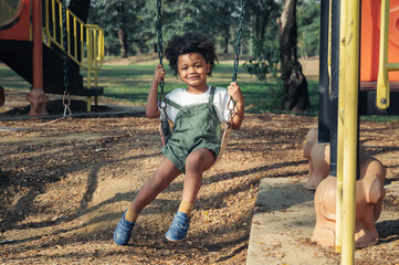 black people child  play swing in playground