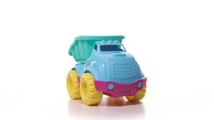 Fototapeta premium Toy car isolate on white background. Toy truck turquoise blue yellow and red color on turntable spin.