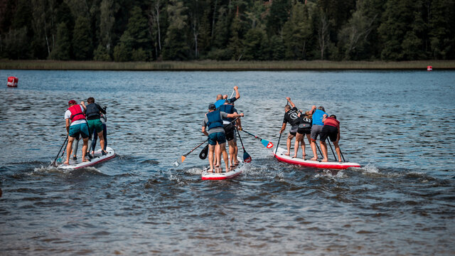 People compete with SUP stand up paddle boards in competition, race. - Powered by Adobe