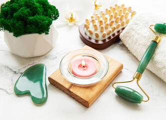 Face massage jade roller  on white marble background