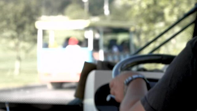 Close-up of driver hand on steering wheel driving a tourist to sightseeing in Singha Park, Chiang Rai, Thailand. Agro-tourism destination focusing on the development of sustainable tourism.