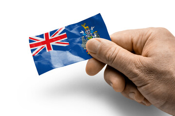 Hand holding a card with a national flag the South Georgia and the South Sandwich Islands