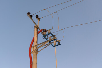 Final concrete power supply pole. Metal wires, ceramic insulators.