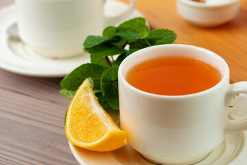 Cup of tea served with lemon and mint