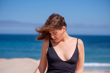 Fototapeta na wymiar Portrait of woman at beach with ocean in background
