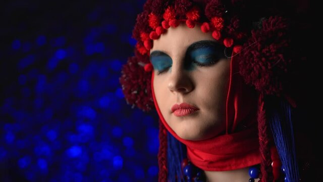 Woman in futuristic ethnic outfit makeup at light glare disco. Medium close up shot on 4k RED camera