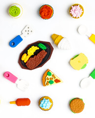 View of miniature toy kitchenware and foods on white background. Image with selective focus and flat lay.