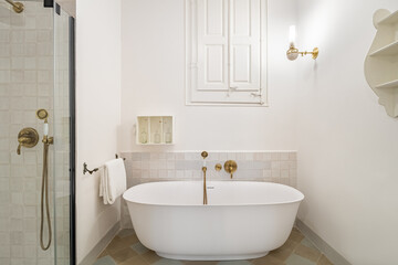 Retro style bathroom decorated in white color with bathtub and shower zone