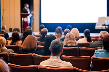 Businesspeople on Conference. Male Presenter  Speaking In Front of the Group of People in The Hall.