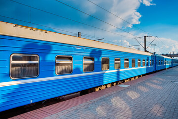 Line of Standard Blue Railway Carriages At Station Platform At Daytime.
