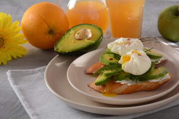Poached eggs and sandwiches with avocado. Sliced avocado and egg on toasted bread for healthy breakfast or snack