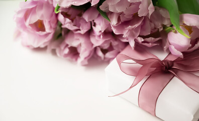 Close up of a gift beside a bunch of tulips. Women's day, mother's day, birthday, anniversary concept.
