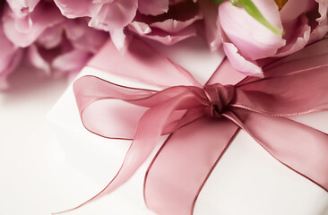 Close up of a gift beside a bunch of tulips. Women's day, mother's day, birthday, anniversary concept.