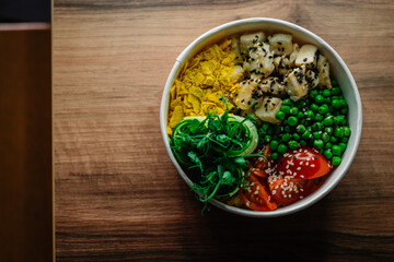 Bowl with chicken on wooden table