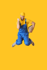 Jumping male worker on color background