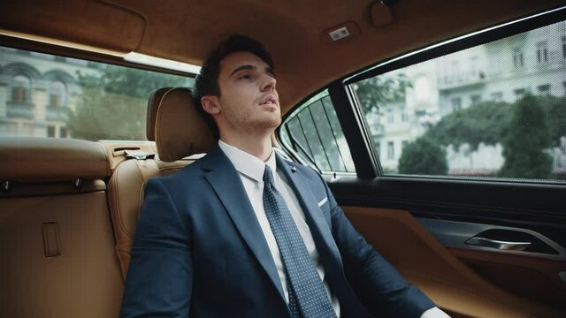 Tired business man resting at back seat of modern car. Businessman relaxing