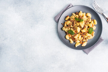 Stewed pasta with minced beef and vegetables, macaroni in Navy style on a plate. grey concrete background. Copy space.