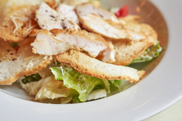 Caesar salad plate. Health food at cafe. Bread crouton, chicken, tomato, cheese in bowl. Top view. Closeup view. Freeshness gourmet. Italian cuisine