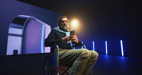 Mature speaker with disability showing new cellphone on stage