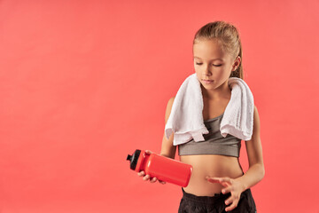 Cute sporty girl holding bottle of water