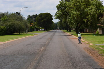 Lonely kid riding a bicycle down empty street during lockdown 2020