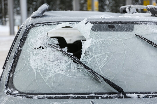 Broken Windshield Of A Car After An Accident In Winter. A Hole In The Windshield Of A Car Due To A Not Fastened Seat Belt. Car Glass Is Broken By The Head Of The Driver Or Passenger 