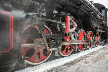wheels of an old steam locomotive in winter close up