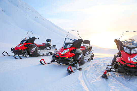 Kirovsk, Russia - FEBRUARY 1, 2021 red snowmobiles brp lynx adventure lx 600 on a background of snowy mountains on a sunny day. 