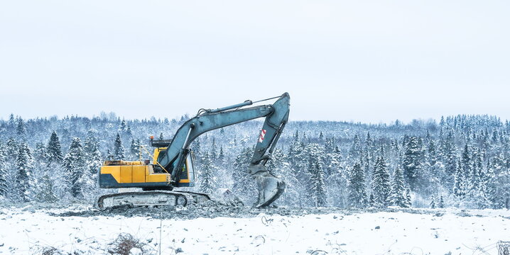 excavator works at a construction site in winter 