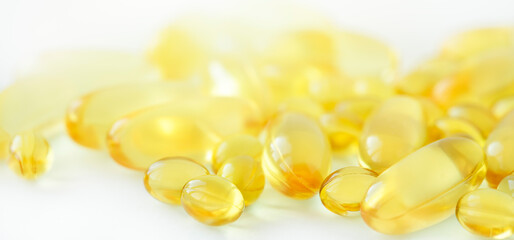 Yellow capsules of fish oil on light background