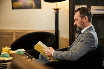 Focused elegant man reading a breathtaking book