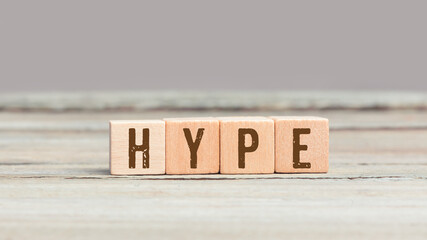 Hype word on wood cube dices on aged table.