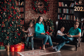 A family with three children decorates a Christmas tree