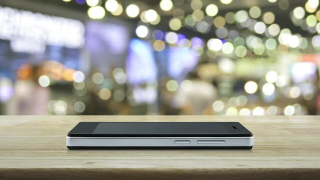 cctv camera flat icon on modern smart mobile phone screen on wooden table over blur light and shadow of shopping mall, Business security and safety online concept