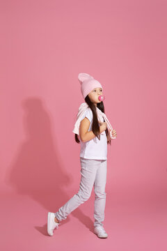 cool hipster little child girl with chewing gum on pink background
