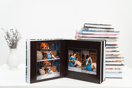 stack of books. open photobook from photo shoots of beautiful brunette woman 