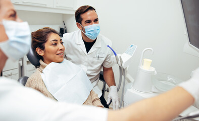 Dentists and patient looking at x-ray image