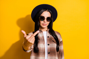 Photo of young aggressive woman mad crazy show fucking sign you wear retro hat isolated over yellow color background