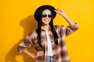 Photo of young attractive girl happy positive smile wear hat sunglasses isolated over yellow color background
