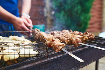 Grilled kebab cooking on metal skewer. Roasted meat cooked at barbecue. BBQ fresh beef meat chop slices. Traditional eastern dish, shish kebab. Grill on charcoal and flame, picnic, street food.