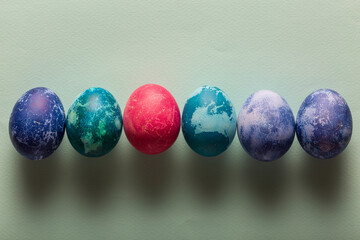 Multicolored Easter eggs on a blue background, top view