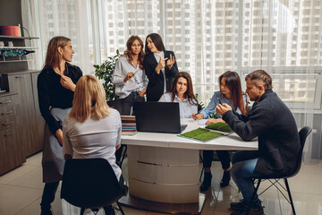 Fototapeta premium Group of seven people, a man and women, actively discussing their project and conducting discussions in joint work. Productivity concept