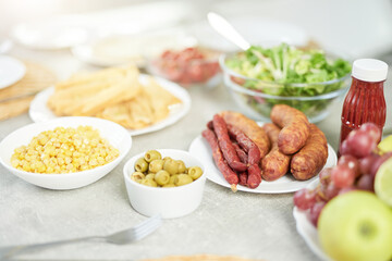Traditional food. Close up shot of Latin style breakfast with corn, olives, salad and meat on the bright white kitchen table