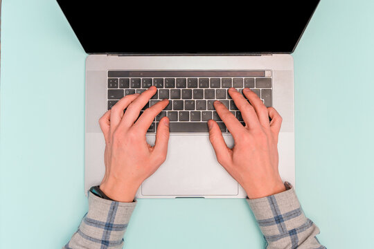 Men's Hands Work Behind Laptops On A Blue Desk, Top View And Space For Text